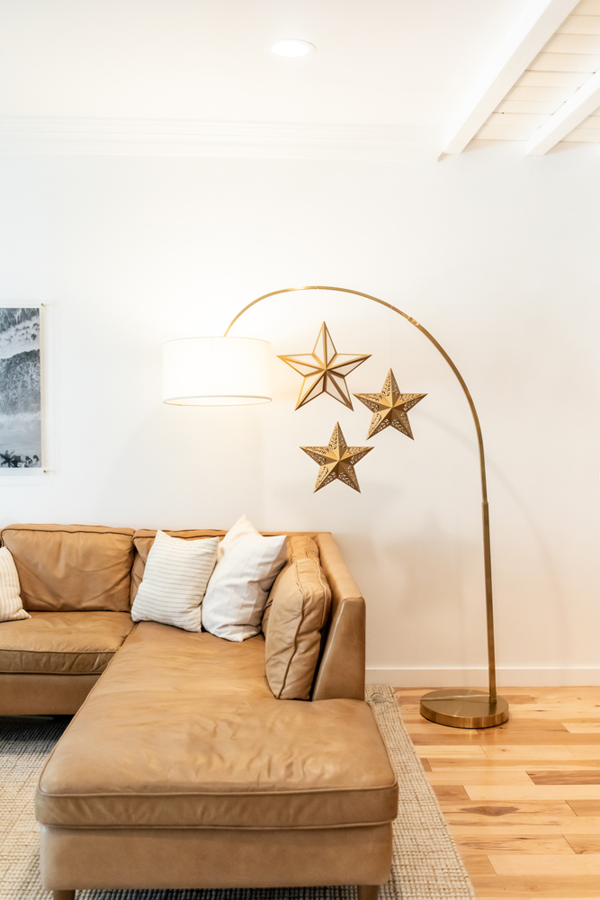 Three paper star lanterns hanging near lamp